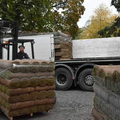 En glad lastbilschaufför som lossar en gräsmatteleverans hos en av Gräscenters kunder.